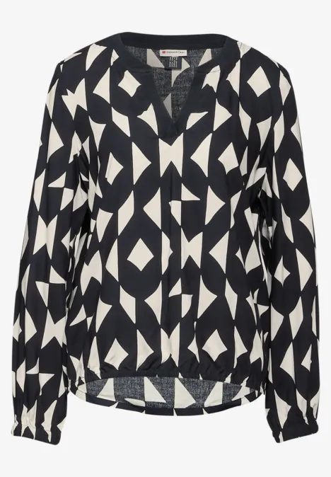 Schwarze Bluse mit weißem, geometrischem Muster und langem Arm.